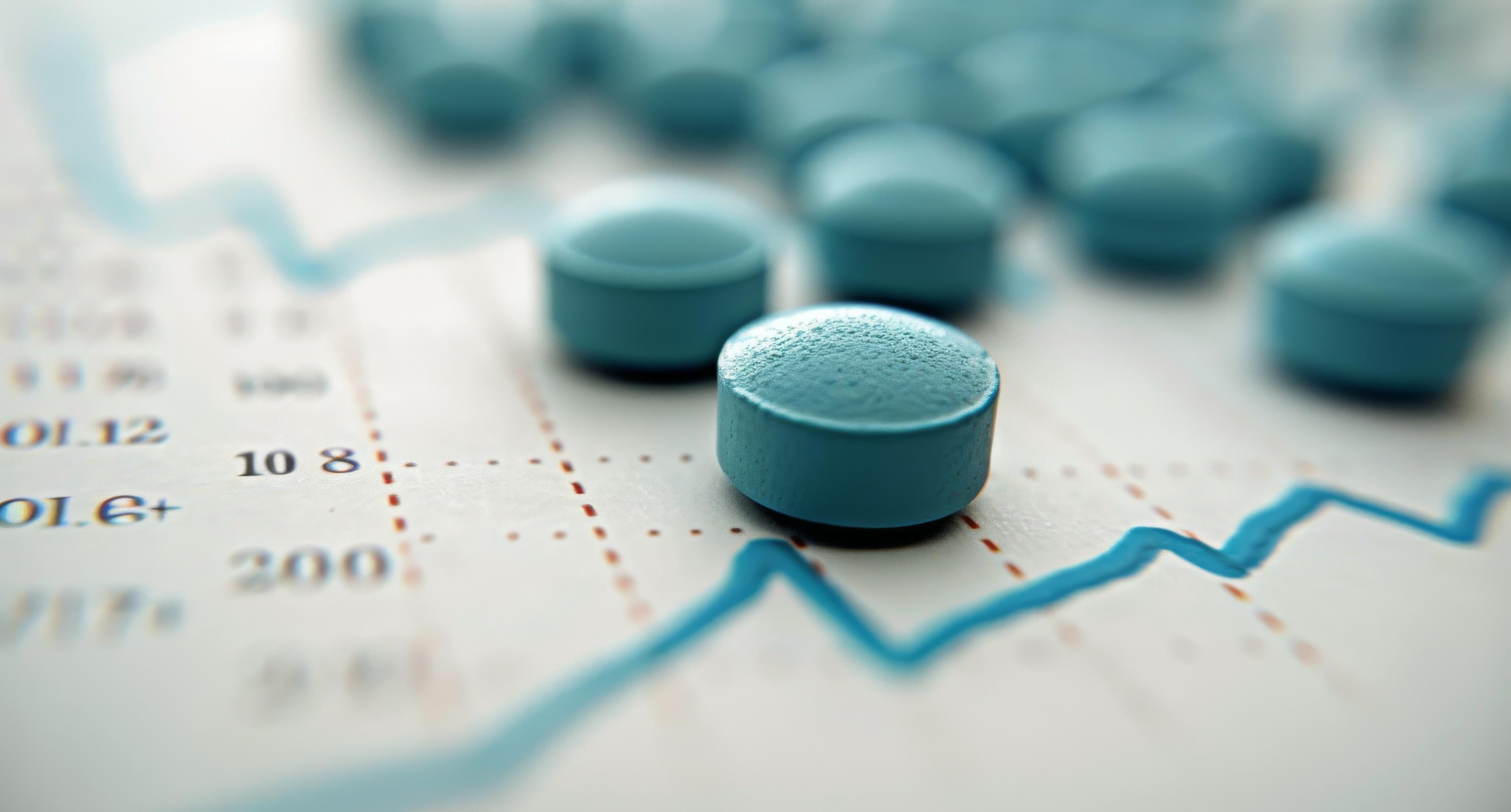 Blue round bi-concave tablets on a white sheet of analytical paper.
